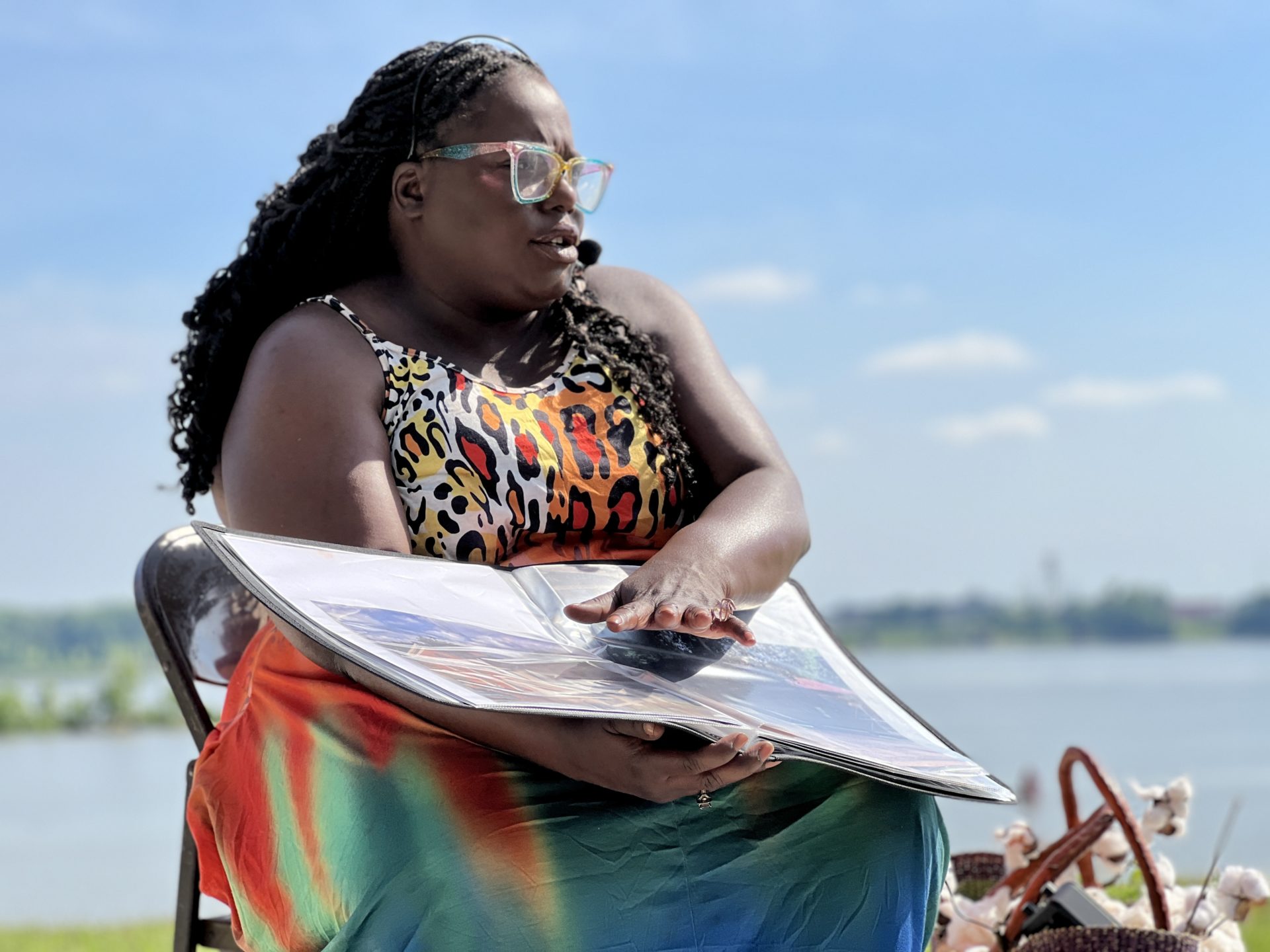 woman reading from a large folio wearing a mobile microphone